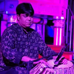 Performing in a contemporary setting with vibrant stage lighting. This image captures the focused energy I bring to my fusion performances, where I adapt the tabla to genres like rock, jazz, and Sufi music.