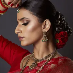 A closer look at my signature bridal style. I created a sharp, smokey eye and paired it with a flawless, glowing base. The traditional bridal bun is adorned with fresh red carnations for a classic royal touch.