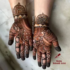 This design is a celebration of traditional motifs, featuring a playful elephant band on the wrists, lotus flowers on the fingers, and a central paisley pattern.