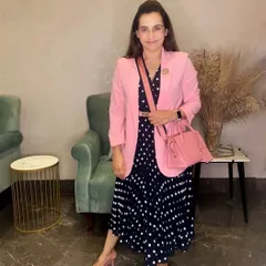 This outfit shows the power of using a pop of color to tie everything together. The pink in the blazer, shoes, and bag creates a cohesive theme against the neutral navy polka dot dress, resulting in a thoughtful and professional appearance.