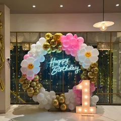 A cheerful and bright first birthday for Kiyaya. I designed this circular balloon arch with white, pink, and gold balloons, adding cute smiley-face daisy balloons for a fun touch. The light-up '1' and foil name balloons complete the personalized setup.