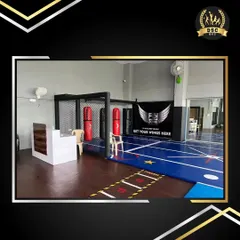 The reception and entrance area of the Fly Zone fitness center. The facility includes punching bags and a caged practice area for combat sports training.