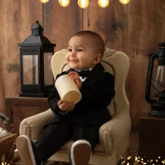Even a 'Boss Baby' has a soft side. This little guy in his tuxedo is all smiles during his fun, themed one-year-old photoshoot.