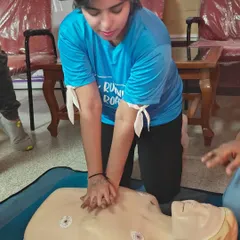 A member gets hands-on practice with chest compressions on a CPR manikin. This practical training is crucial for learning the correct technique and building muscle memory.