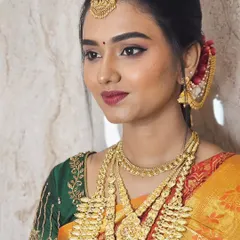 For Soundariya's muhurtham, we chose a classic look with winged eyeliner and a beautiful berry lip color. Her skin is glowing, and the makeup perfectly matches her green and orange Kanjivaram saree.