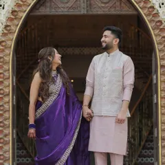 A classic couple portrait of Devanshi and Anshul. Standing in a beautifully carved archway, their shared look and hand-hold create a timeless and romantic image from their wedding day.