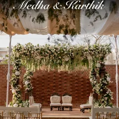 Against a rustic brick wall, this engagement mandap is a vision of modern elegance. A lush canopy of hanging white and pink florals creates a dreamy, fairytale-like setting, perfect for a contemporary celebration at The Secret Grove.