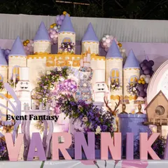 A closer view of Varnnika's fairyland stage, highlighting the intricate castle backdrop, the large "VARNNIKA" letters, and the adorable fairy and deer props.