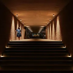 A dramatic, brick-lined corridor at Samavana, where carefully placed uplighting creates a powerful sense of arrival. This long, symmetrical passage is designed to build anticipation as guests move through the space.