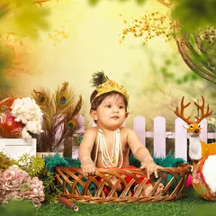 A wider view of the Janmashtami themed photoshoot, showing the complete setup with a wicker basket, forest backdrop, and decorative elements that create a rich, storybook feel.