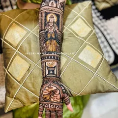 A detailed view of one arm, featuring the portrait of Lord Vitthal inside a temple motif. Below the portrait are other symbolic elements like a tulsi vrindavan and a veena.