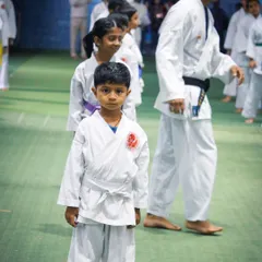 A young student stands with focus and readiness during his belt grading event. My program instills discipline and composure in children, preparing them to perform under pressure.
