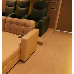 This shot shows the combination of a comfortable daybed in the front and premium, dark green leather recliners in the back, offering flexible seating options for this Nellore home.