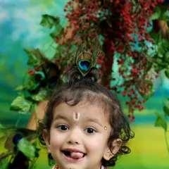 A delightful close up shot highlighting the intricate details of the costume and the child's infectious smile. These portraits are perfect for celebrating Janmashtami or as a timeless keepsake.