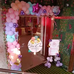 A beautiful pastel balloon arch decorating the entrance to a party venue.