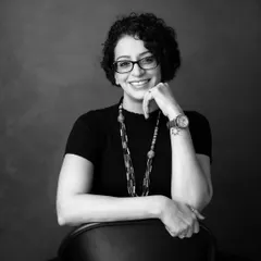 Black and white brings a timeless and focused quality to a professional headshot. This image strips away distractions, highlighting her confident expression and warm personality, making it a powerful choice for her personal brand.