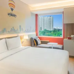 A guest room at the Ibis Hotel in Thane, where modern, efficient design is enhanced by a custom wall mural depicting the Mumbai cityscape, reflecting our approach of infusing local culture into our interiors.