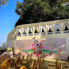 The seating arrangement for a daytime wedding, with a beautiful hand-painted Pichwai art backdrop depicting Shrinathji. I love incorporating local art forms to give the wedding a unique and culturally rich feel.