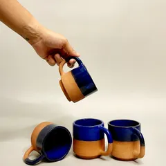 My handmade mugs, like these in a striking cobalt blue and terracotta, are crafted for comfort and style. Each one is unique, making them a popular choice for cafes wanting to stand out.