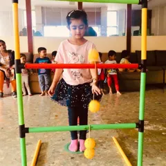 A young girl carefully aims her shot in the ladder toss game. I ensure every child gets a chance to practice and develop their skills at their own comfort level.
