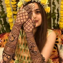 A beautiful bride-to-be with a floral crown, her hands adorned with our detailed peacock and geometric mehndi designs.