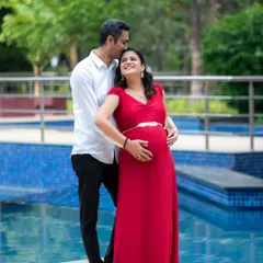 A romantic poolside portrait of an expecting couple. The dad-to-be's gentle kiss on her forehead perfectly captures their love and anticipation.