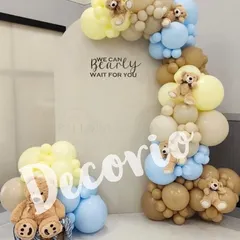 Here is another take on the "We Can Bearly Wait" theme, using a soft color palette of blue, yellow, and tan. The balloon arch is dotted with tiny teddy bears, adding an extra layer of detail and charm to the baby shower decor.