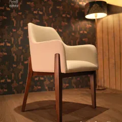 This armchair embodies quiet luxury. With its smooth, off-white upholstery and gracefully curved wooden legs, it offers a perfect blend of modern design and timeless comfort. It’s an elegant addition to any living space or reading corner.