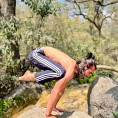 Bakasana on a rock in the middle of a stream. Arm balancing in nature requires an intense level of focus and connection to your surroundings.