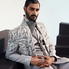 A closer look at the modern grey ensemble. The collar is heavily embellished, and the jacket's embroidery uses geometric patterns to create a contemporary feel. This is bespoke elegance for the modern man.