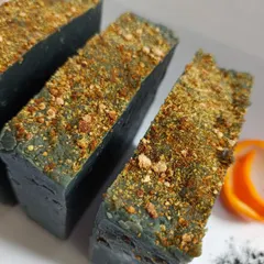 A close-up of my Charcoal Orange artisanal soap bars. You can see the real orange peel embedded in the soap, which provides gentle exfoliation, while activated charcoal purifies the skin.