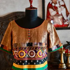 I design custom blouses that are as unique as the sarees they accompany. This kurti-style blouse is crafted from antique gold linen silk, detailed with a band of vibrant Kutch tribal embroidery and a patchwork trim made from studio scraps.