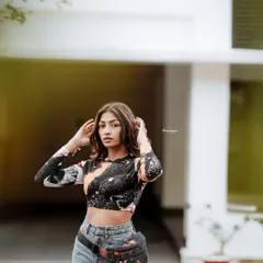 A confident pose from the same outdoor session. The clean background helps the model and her colorful top stand out.