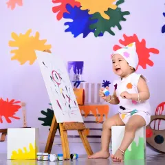 A little Picasso at work! The 'Little Artist' theme is a splash of color and fun. I set up a mini easel and non-toxic paints for a creative session that's as fun for the baby as it is for the camera.