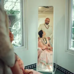 A creative composition using a mirror to capture a tender moment between the couple as they get ready.