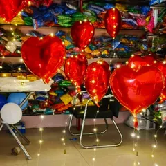 Set a romantic mood with our heart-shaped foil balloons. Here, we've paired vibrant red heart balloons with twinkling fairy lights, creating a magical atmosphere perfect for Valentine's Day, anniversaries, or a special surprise.