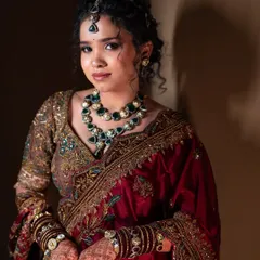 A solo portrait of Lavanya, looking radiant. Her makeup features a modern glass-skin finish and a textured updo, inspired by celebrity bridal looks.