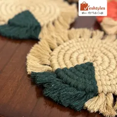 A close-up of the jute and dark green table coaster. The spiral design and fringed edge give it a lovely rustic look.