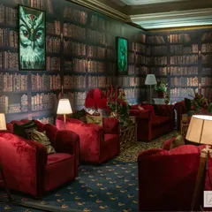 Cozy corners were a key feature of our speakeasy party. I created intimate seating areas with plush red velvet armchairs and library-themed backdrops, offering guests a quiet place to chat with a classic drink in hand.
