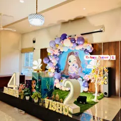 A wide view of a mermaid-themed party, showing the full stage setup in a home. This design includes multiple character props and light-up numbers for a joint birthday celebration.