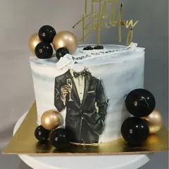 A classy cake for a gentleman, featuring a tuxedo illustration and black and gold spheres.