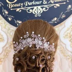 This is an example of the advanced bridal updos we teach. This style features delicate curls pinned into a low bun, accented with a beautiful crystal and pearl hair accessory.