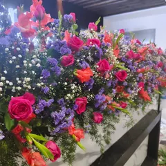 A close up view of a dense floral arrangement, showing the quality and freshness of the flowers I use, including roses, gladiolus, and baby's breath.