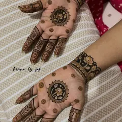 A stunning bridal design with a central lotus mandala on each palm. The fingers feature leafy patterns, and the wrists are adorned with thick, floral bands, creating a balanced and elegant look.