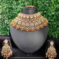 A classic and heavy bridal choker set available for rent. This piece features intricate kundan work with uncut polki stones and comes with large, matching chandelier earrings.