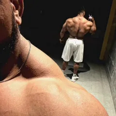 An artistic over-the-shoulder shot showing back and trap development.