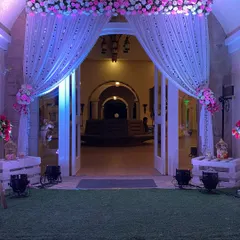A simple yet elegant entrance to the main hall at Raheja Exotica. We used soft white drapes, floral tie-backs, and uplighting to create a warm and inviting doorway for the reception.