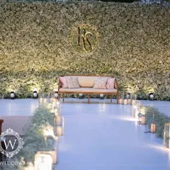 An elegant all-white reception stage, featuring a lush wall of baby's breath and a custom monogram for the couple. This design proves that simplicity can be the ultimate sophistication, creating a timeless and romantic backdrop.
