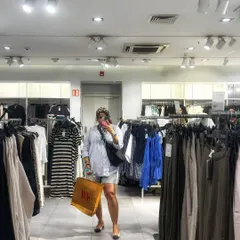 A mirror selfie during a shopping trip. This outfit, featuring an oversized striped shirt, denim shorts, and a bandana, is all about relaxed, main character energy for a day of retail therapy.