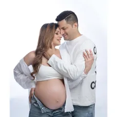 Bumping and blooming with love. This intimate and stylish pose captures the close bond between the couple, with a modern, casual wardrobe that feels authentic and real.